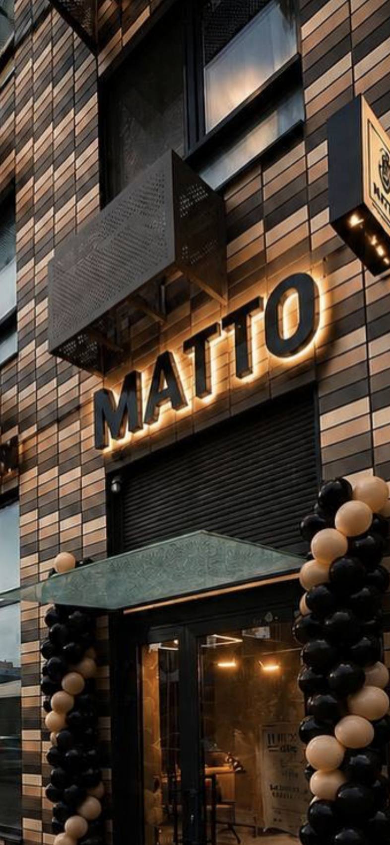 Вход в барбершоп Matto с подсвеченной вывеской